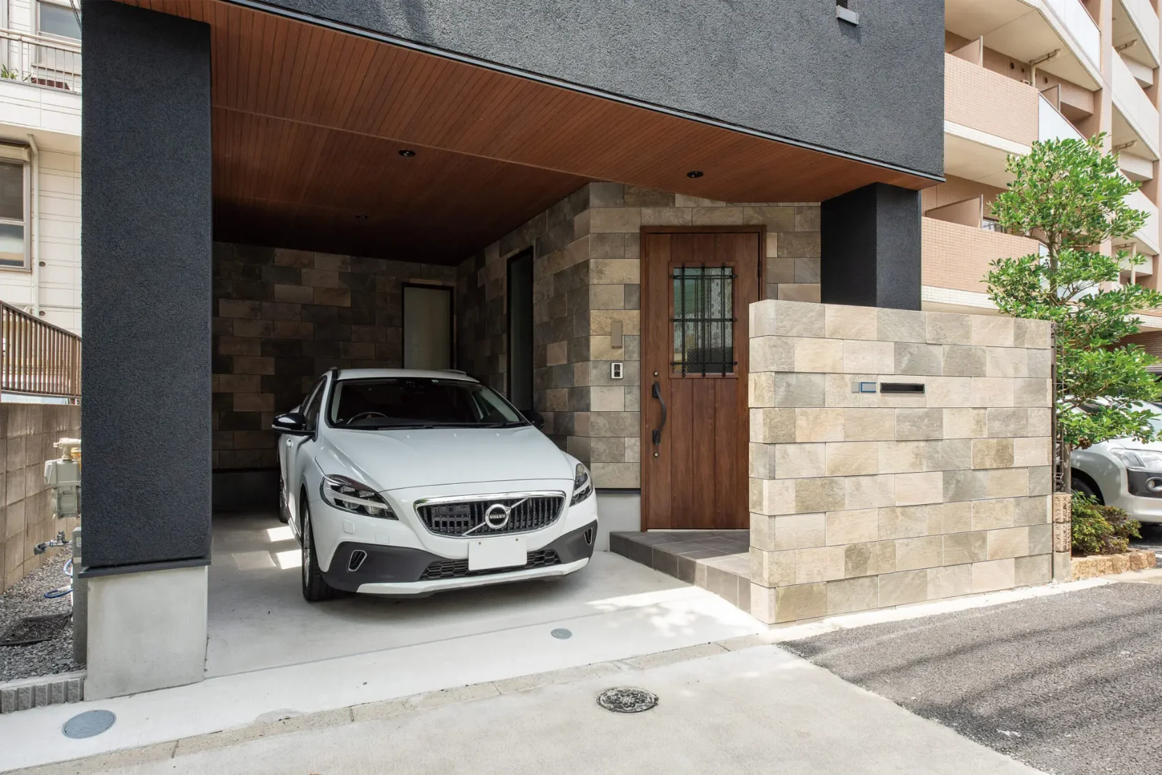 ビルトイン天井に木彫の素材を施工。エントランを含めタイルを貼ることで重厚感のある外観となっている。