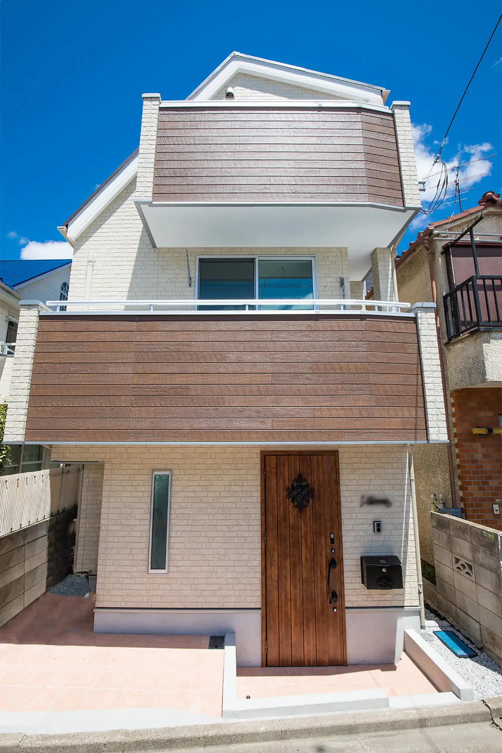 アイボリー石目調のサイディングをベースに木彫のサイディングをアクセントにデザイン。